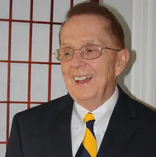 A man in a suit and tie smiling.